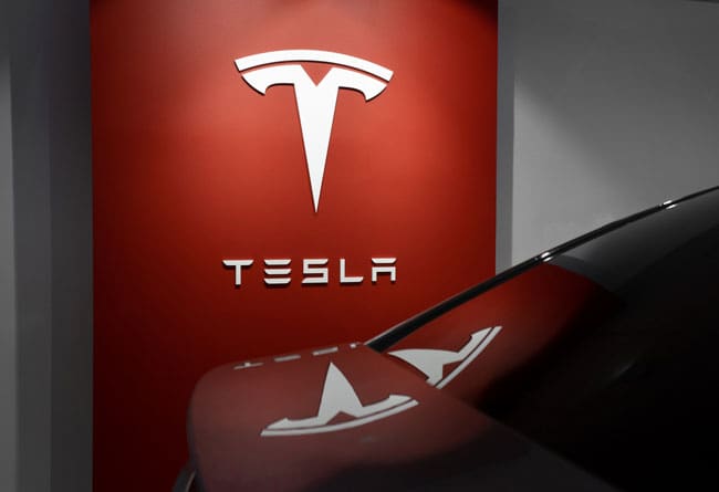 tesla-service-bilverksted-ski Tesla Logo på veggen ved siden av Tesla elbil på Service